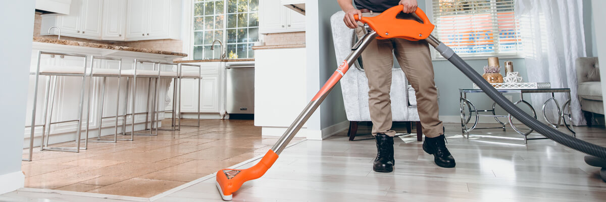 Technician extracting water from a hardwood floor after a home water leak